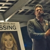 Ben Affleck as murder suspect Nick Dunne beside a poster of missing wife Amy Dunne, played by Rosamund Pike